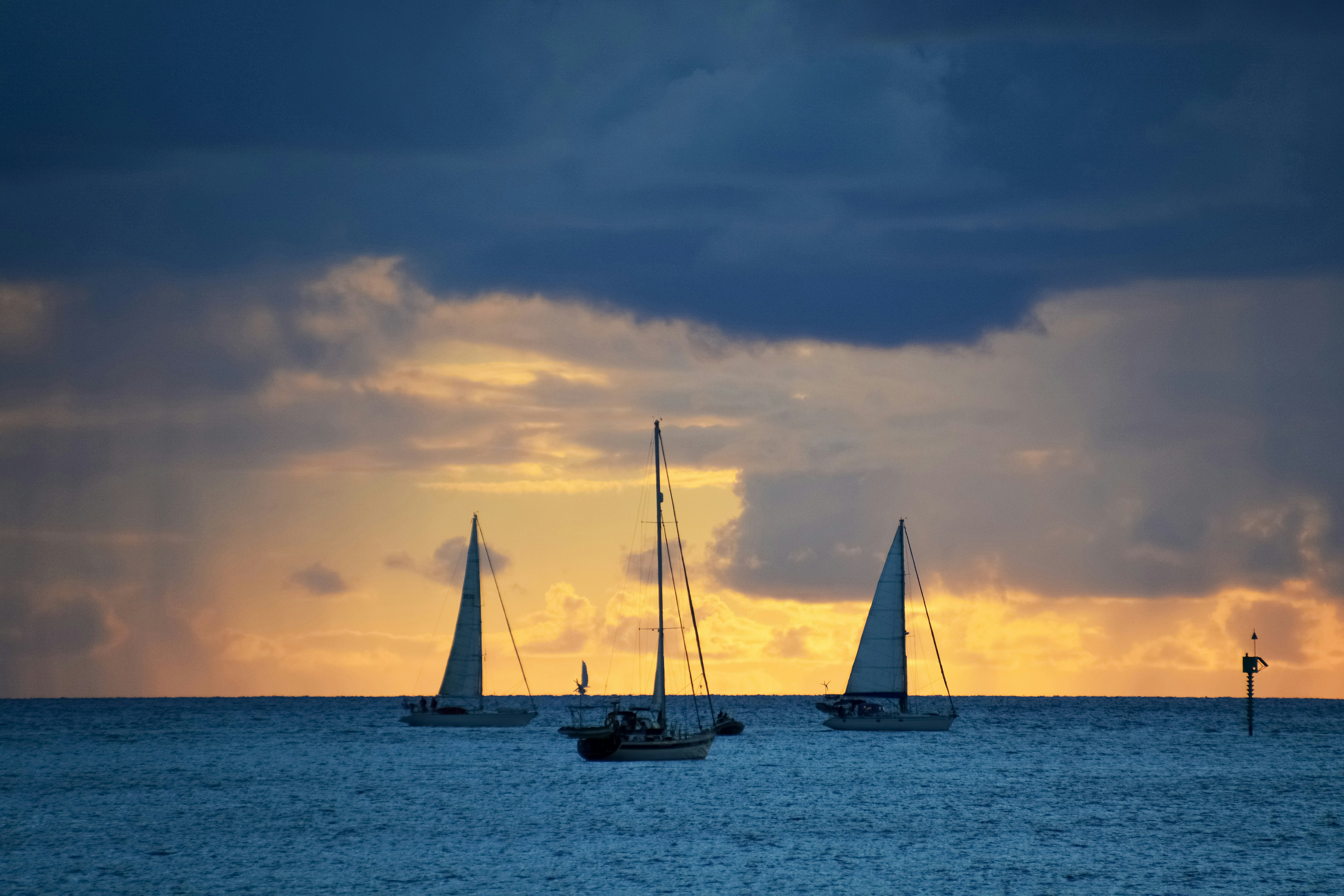 silhouette of sail boat on sea during sunset